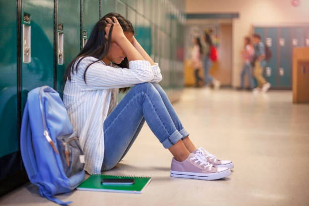 Frustrated teenage female student sitting with head in hands possibly during an emergency response