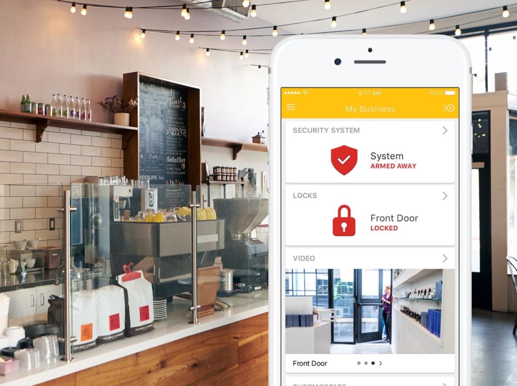 Coffee shop with a smartphone display of the MyGuardianAlarm mobile app for businesses.