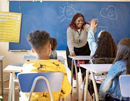 Happy teacher wearing TeachERS emergency response system device to protect students