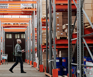 Warehouse employee taking stock of the items on the shelves. Secured by Guardian Alarm Personal Protection system. 