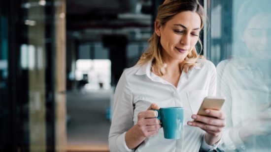 Smiling woman using phone to sign up for Guardian Alarm smart home security camera services
