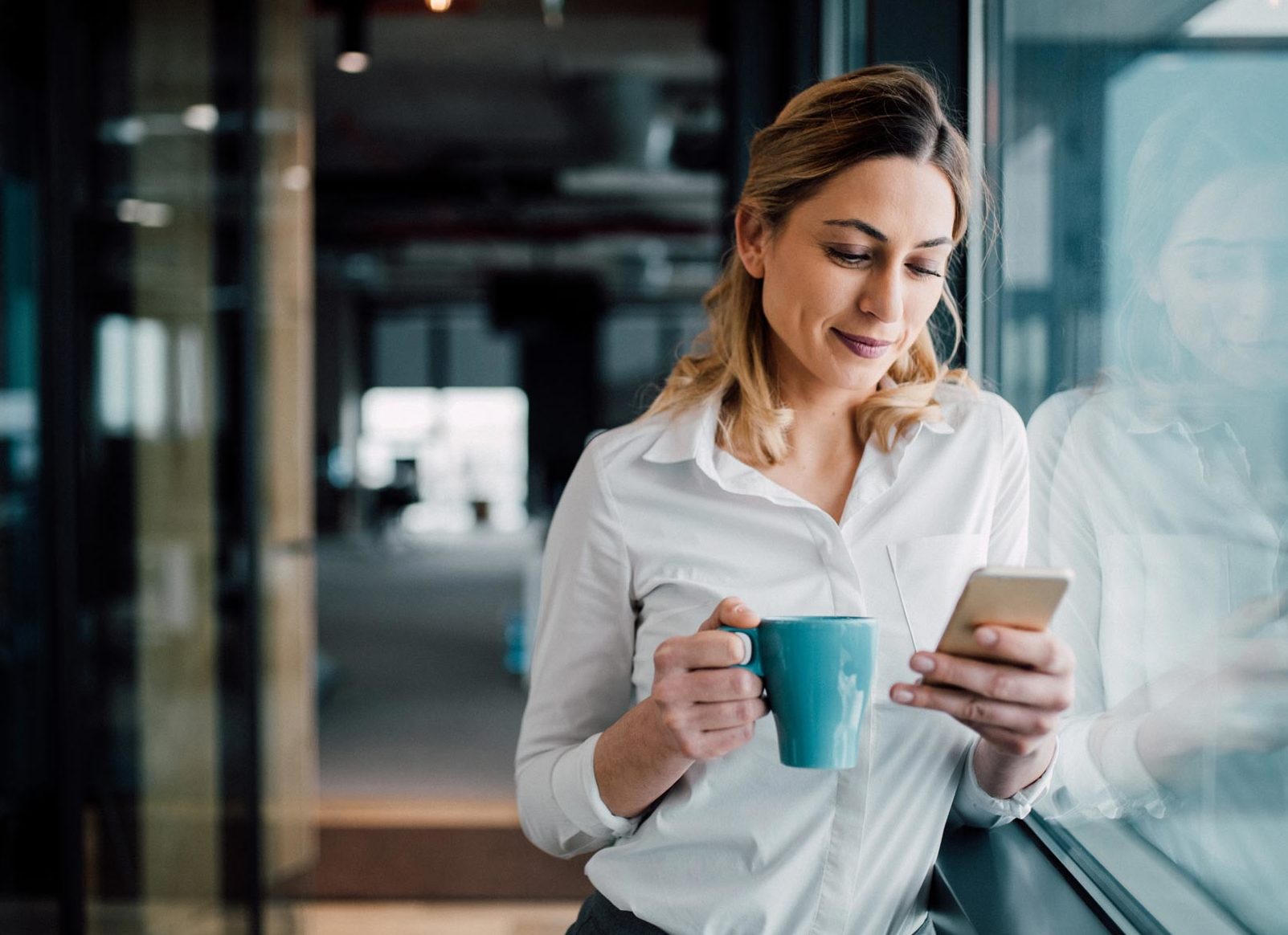Smiling woman using phone to sign up for Guardian Alarm smart home security camera services