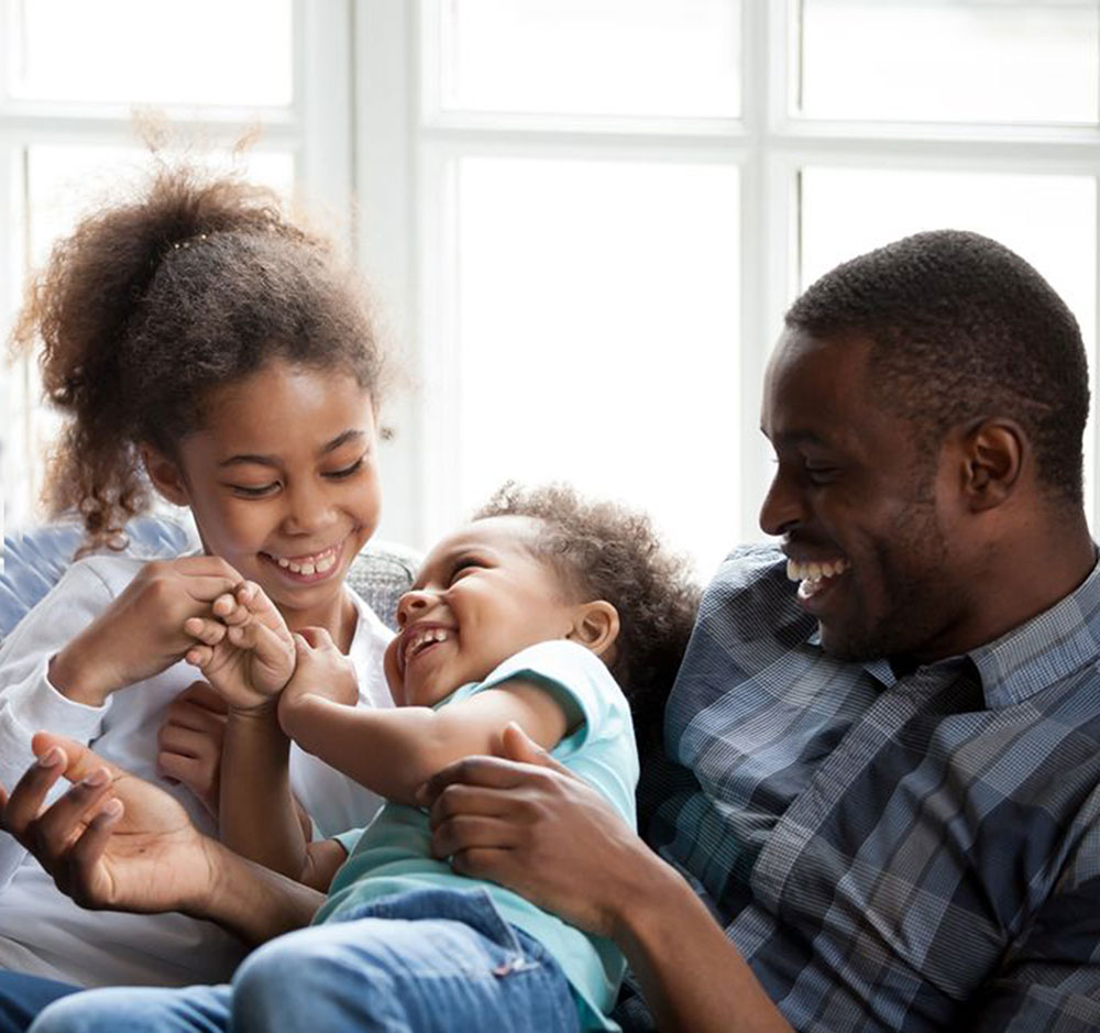 father laughing with his daughters
