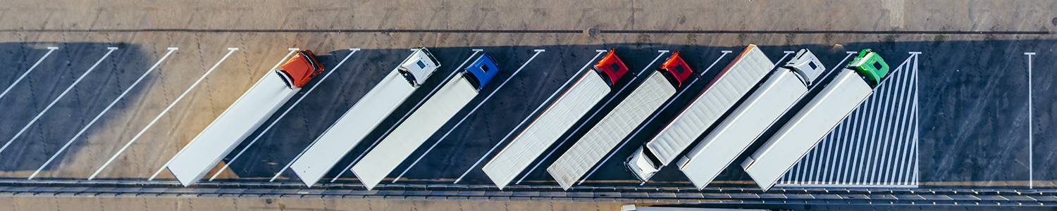 Bird's eye view of semi-trucks parked at a logistics center